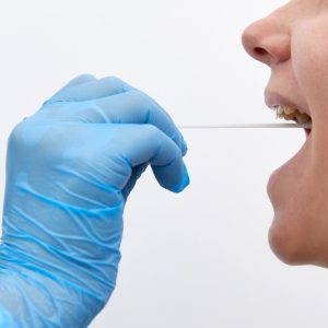 Doctor in a protective suit taking a throat and nasal swab from patient to test for possible coronavirus or covid infection