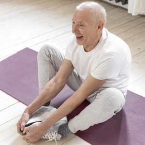 full-shot-senior-man-sitting-mat