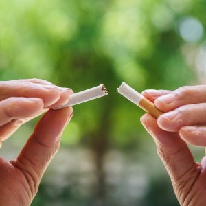 Male hand crushing cigarette on bokeh background, Concept Quitting smoking,World No Tobacco Day.