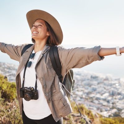 Travel, freedom and woman photographer in nature, happy and relax on adventure and cityscape background. Smile, photography and girl student backpacking, sightseeing and on solo trip in South Africa.