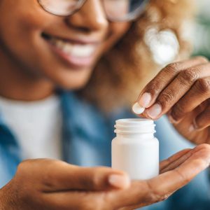 womans-hands-delicately-extracting-pill-from-bottle-reflecting-health-wellness-choices